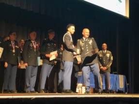 Lt. Colonel Greg Finn presented the SAR JROTC Bronze Medal and certificate to Cadet Orlando Santiago. Deltona High School had a great ceremony with many parents, friends, and presenters in attendance. Cadet Santiago received many awards this evening. His name appears on the screen over the Cadets heads.